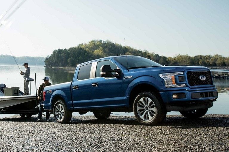 Two people hooking up a boat trailer to a Ford F-150® SuperCrew®