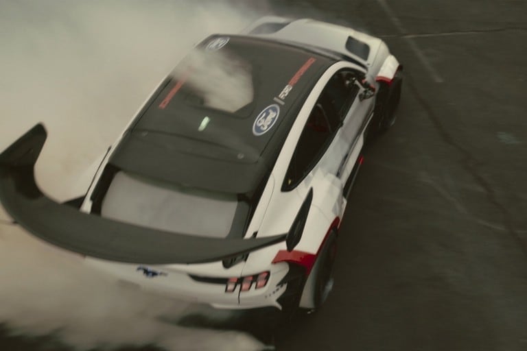 Aerial shot of 2021 Ford® Mustang Mach-E 1400 rapidly turning while blowing smoke