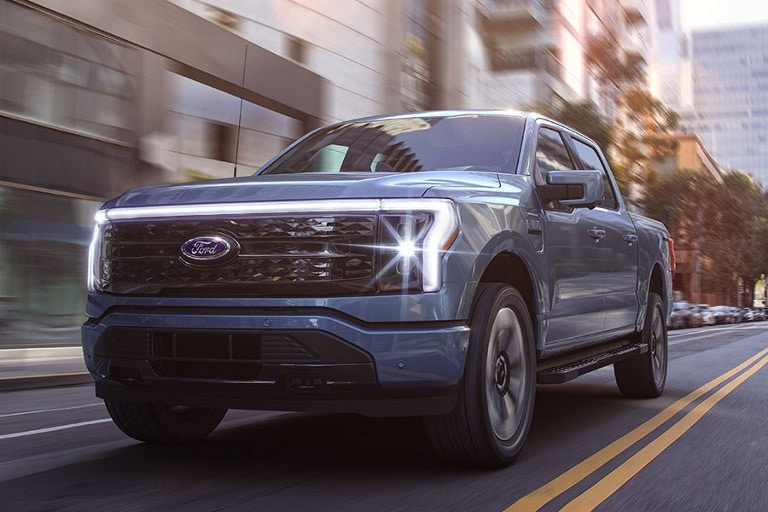 Exterior shot of a 2022 Ford F-150® Lightning™ being driven on a city street