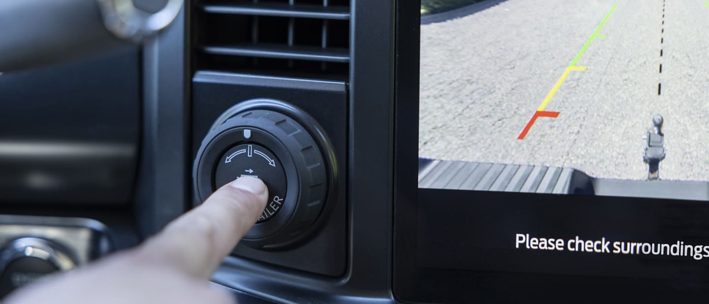 Close-up of a person pressing the Pro Trailer Hitch Assist button in a 2023 Ford Super Duty® truck
