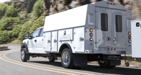 2020 Super Duty Chassis Cab  X L in Oxford White with upfit being driven on curved road near mountains