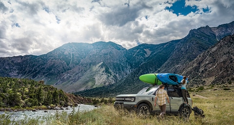 Image of two women unloading kayaks from a Ford Bronco® SUV.