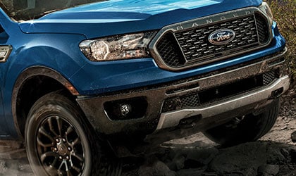 2020 Ford Ranger in Lightning Blue being driven over rocks near mountains